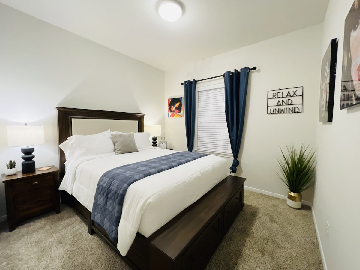 غرفة نوم مريحة للضيوف مع وسائد فخمة وأعمال فنية لإضفاء لمسة ترحيبية.