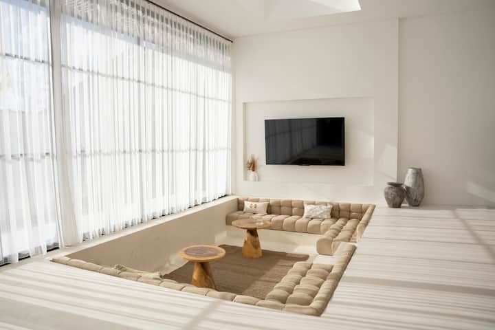 Მისაღები ოთახი ფართო და სტუმართმოყვარეა, იდეალურია დასვენებისთვის. Პლუშის დასაჯდომად საკმარისი სივრცეა, ტელევიზორს კი - გართობა. Ოთახის ღია, ჰაეროვანი დიზაინი ქმნის მშვიდ დიზაინს ნებისმიერი შემთხვევისთვის.