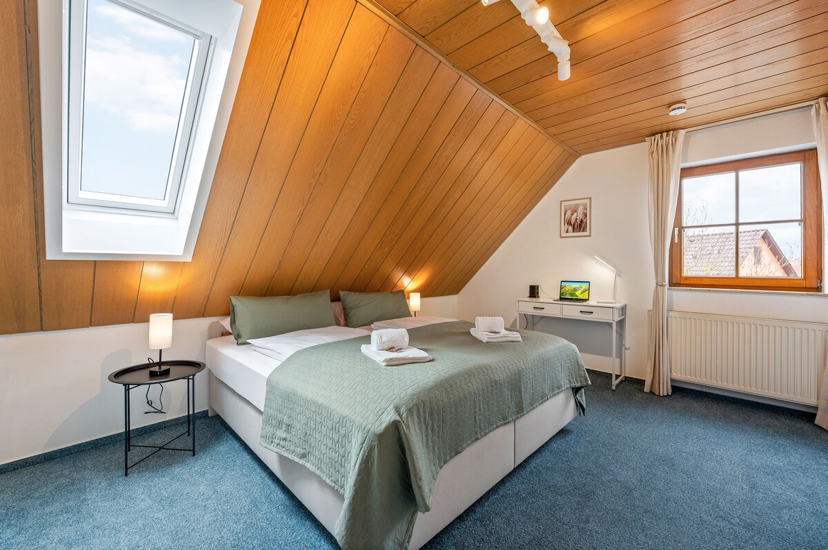 Flexibles Wohlfühlen

Das gemütliche Doppelbett kann auch als zwei Einzelbetten genutzt werden. Im Hintergrund bietet ein kleiner Schreibtisch die perfekte Ecke für konzentriertes Arbeiten.