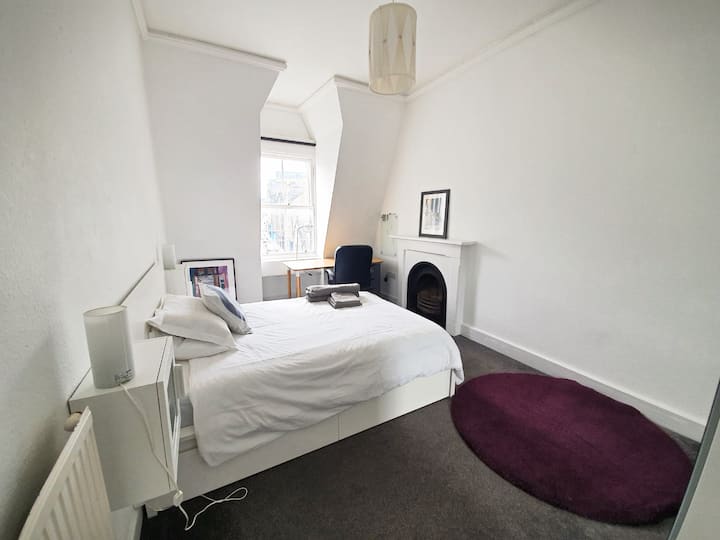 El cuarto y último dormitorio también está equipado con una cama doble y un espacio de estudio que da a una gran ventana con impresionantes vistas. También puedes disfrutar de un fogón de leña decorativo. Por tu seguridad, no utilices el fogón de leña.