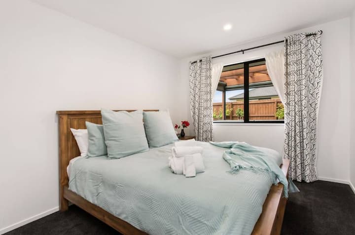 Dhomë gjumi e rehatshme dhe minimaliste me çarçafë të bardhë dhe një batanije të butë.