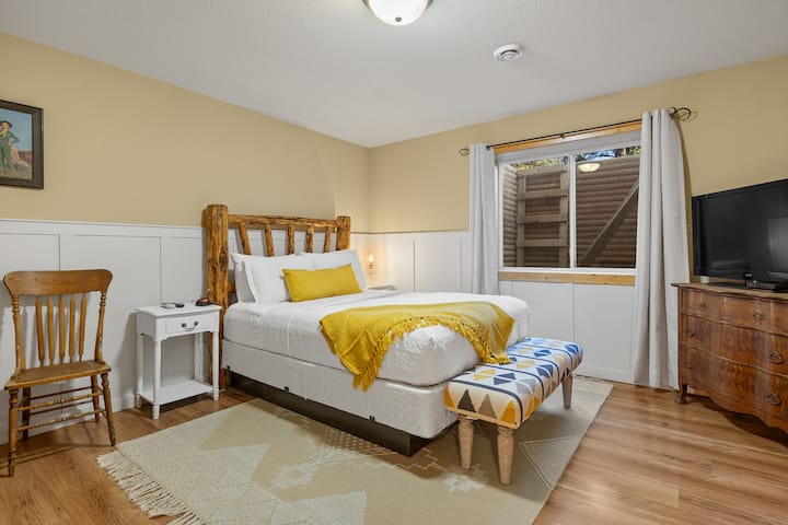 La chambre 4 au niveau inférieur dispose d'un lit queen et de sa propre télévision, offrant une retraite privée et confortable.