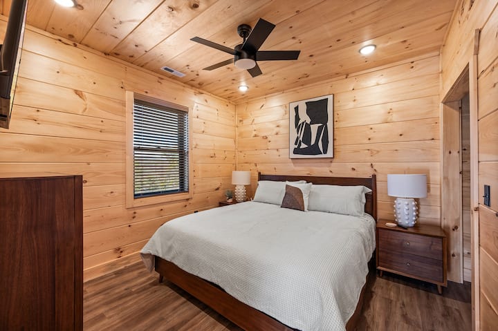 חדר שינה קינג מפלס עליון עם שני שידות לילה, שידה, טלוויזיה ומאוורר תקרה 