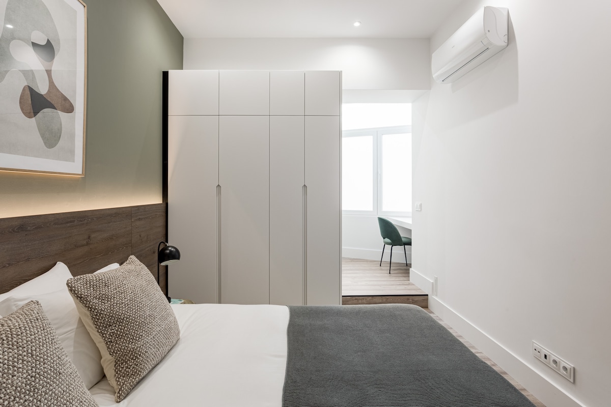 套房配有双人床、衣柜、空调和光线充足的专用工作空间。