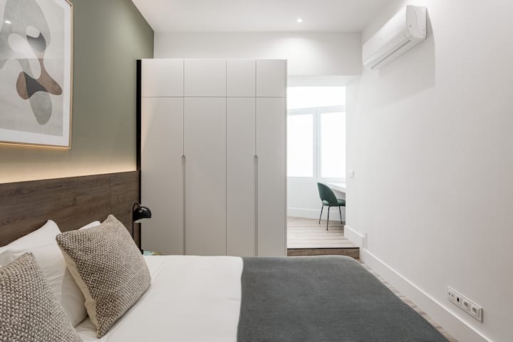 جناح بسرير مزدوج وخزانة ملابس ومكيف هواء ومساحة عمل مخصصة مع الكثير من الضوء الطبيعي.