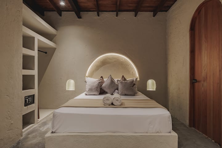 Las habitaciones de Villa La Santísima, con una cama tamaño queen y aire acondicionado, combinan un elegante estilo colonial con el lujo moderno, creando un ambiente sereno y refinado para la relajación.