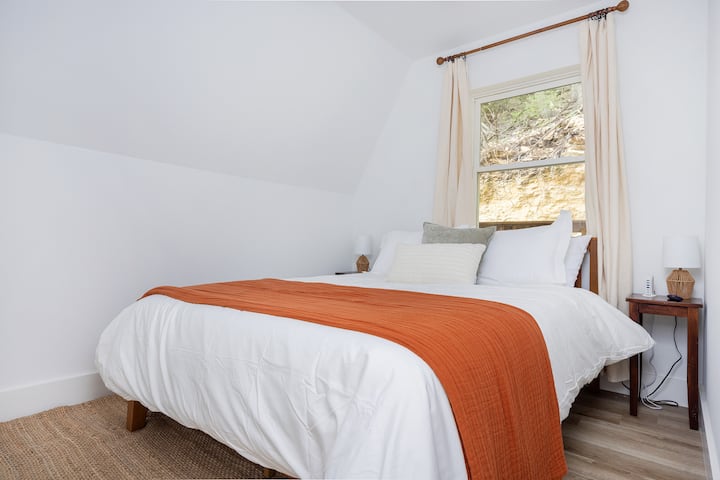 Dormitorio en la planta baja con una cama tamaño queen. 