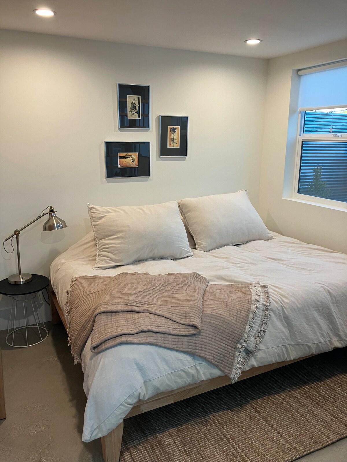 מיטת קווין סייז נגישה בקלות בקומה הראשית עם מסך פרטיות משאר הסטודיו וארון מרווח.