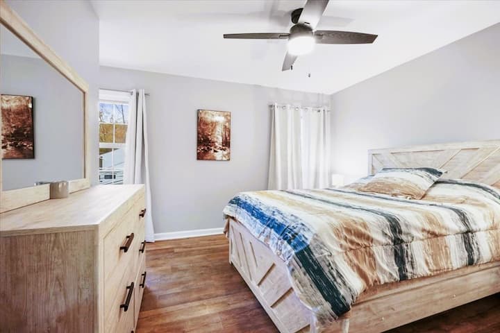 חדר שינה למעלה עם מיטת קווין סייז, וילונות האפלה וחדר רחצה צמוד.