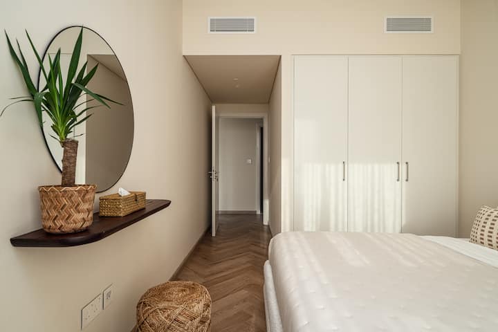 Elegante slaapkamers met pluche beddengoed, moderne inrichting en veel natuurlijk licht door grote ramen.