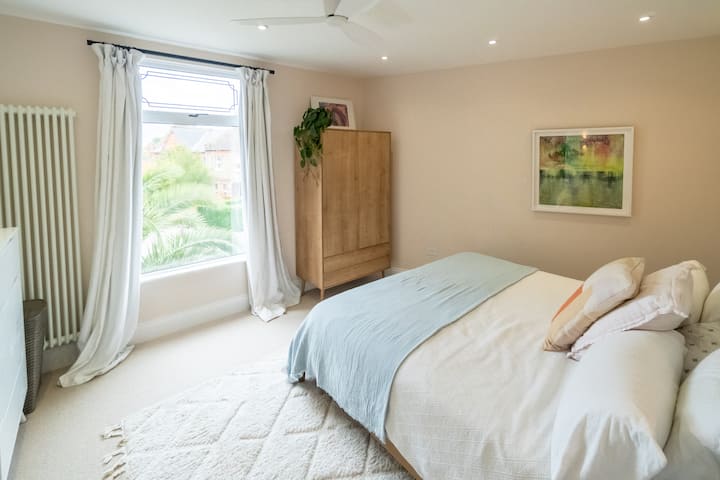 Dormitorio principal con cama tamaño king California en EE. UU. y baño en suite