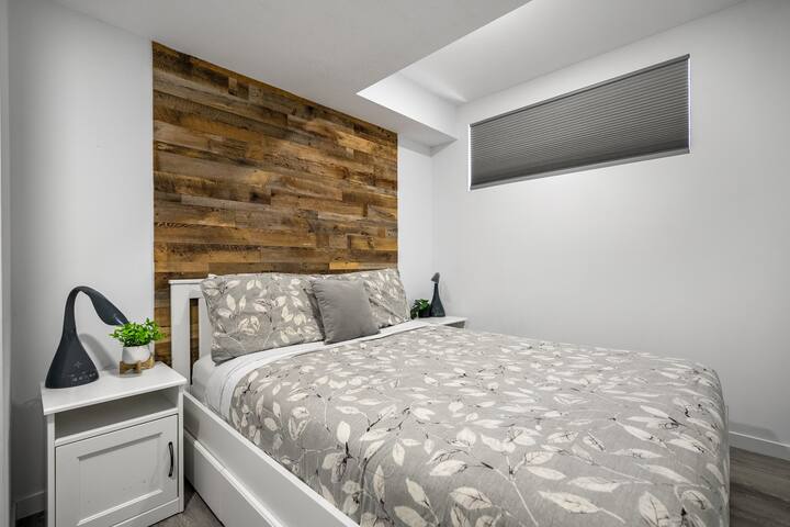 ห้องนอนชั้นล่างมีเตียงควีนไซส์และม่านบังแสง