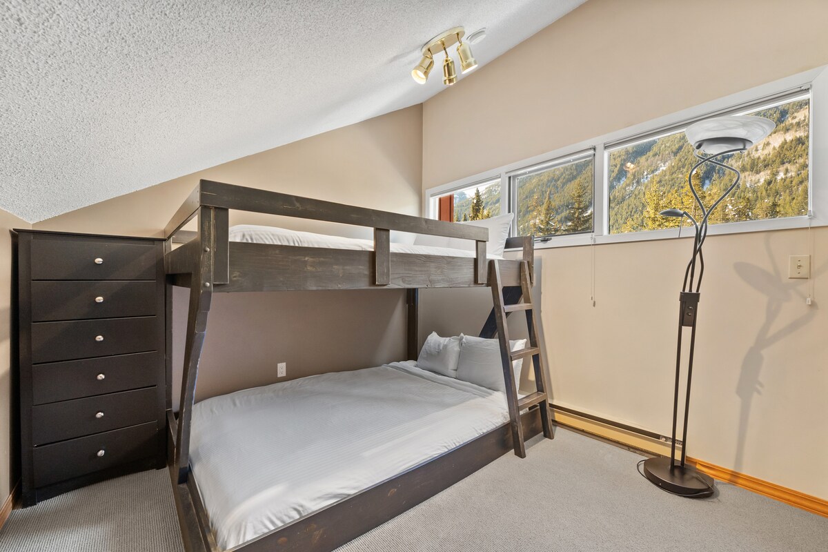 לופט/חדר שינה שלישי, הממוקם בקומה העליונה, עם קומתיים כפולים, שידה ותריסים להחשכת החדר.