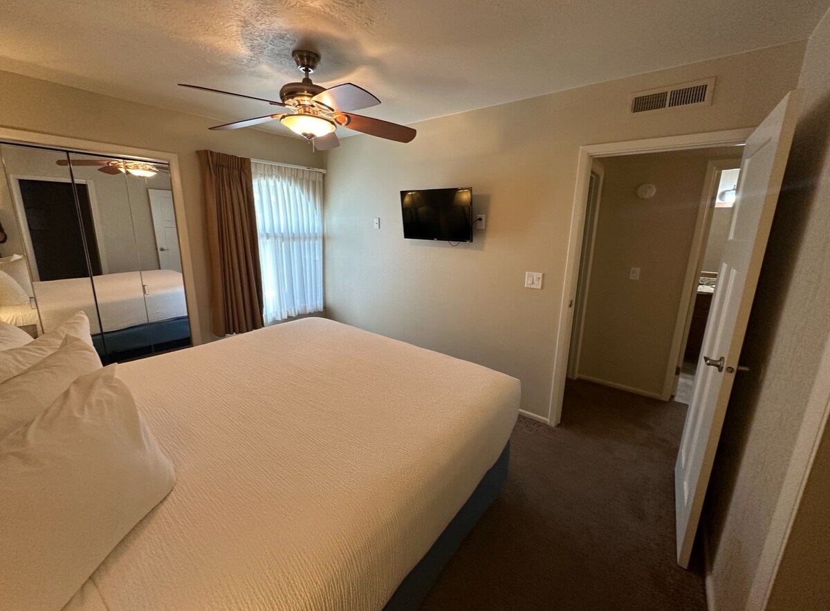 غرفة نوم كبيرة بسرير ملكي وتلفزيون.