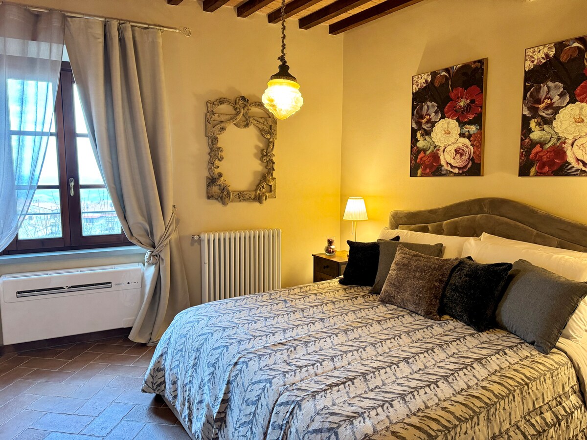 宽敞的卧室配有双人床、空调、瓷砖地板，可俯瞰托斯卡纳乡村的美景。