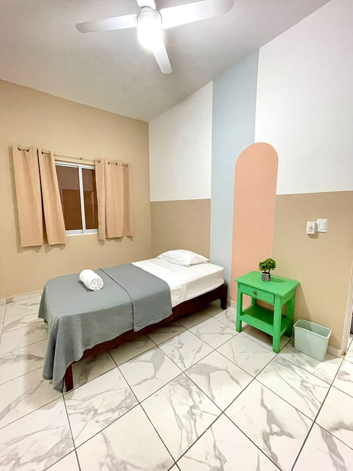 חדר עם מיטת יחיד ומאוורר תקרה 