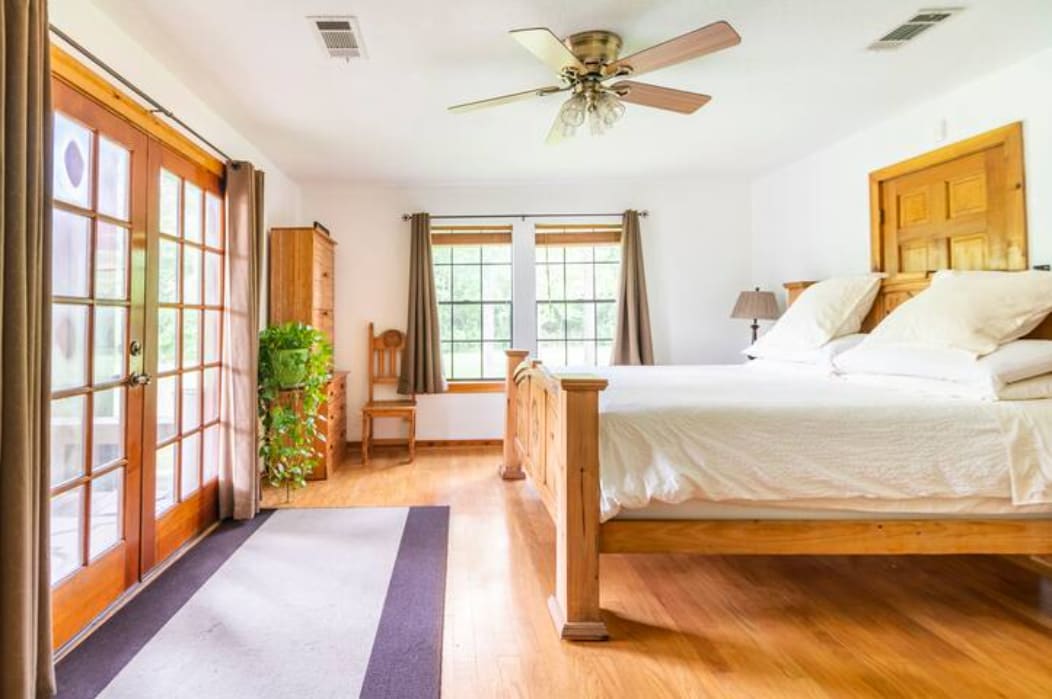 Primary Ensuite Bedroom Downstairs: Private entrance to back deck/pavilion area. Adjacent to hot tub.