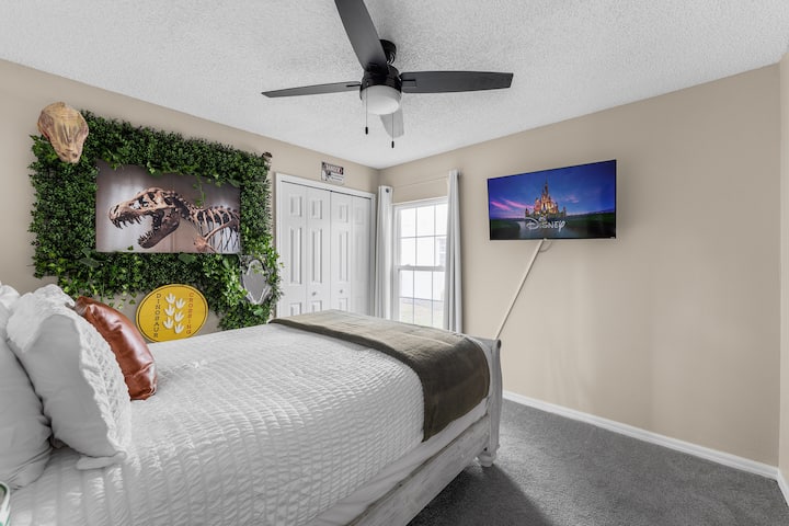 Spálňa v štýle Jurského parku s manželskou posteľou a televízorom, ideálna na dobrodružný pobyt.