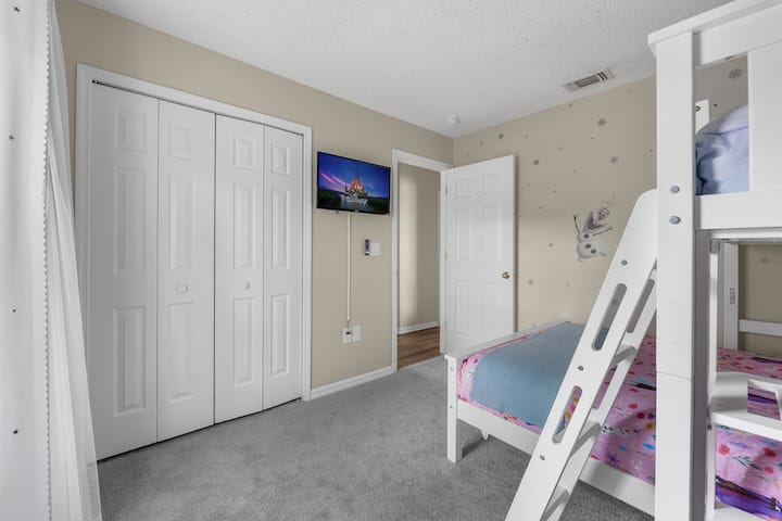 Magická spálňa s mrazenou tematikou s rozmarnou poschodovou posteľou a televízorom, kde každý okamih pôsobí ako zasnežené dobrodružstvo.