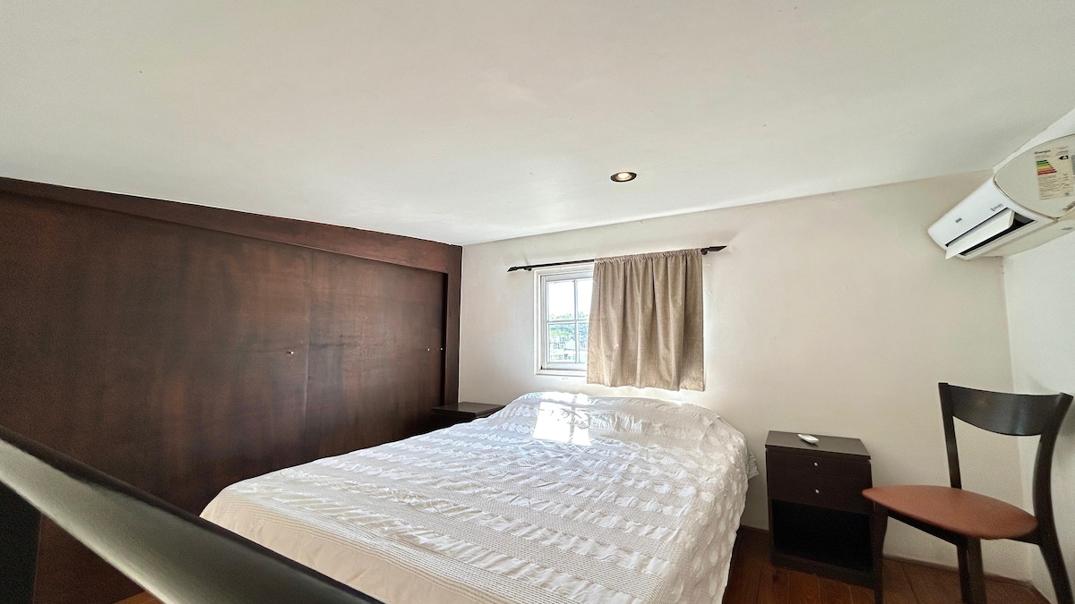 Soba s bračnim krevetom, klima-uređajem i prostorom za odlaganje odjeće.