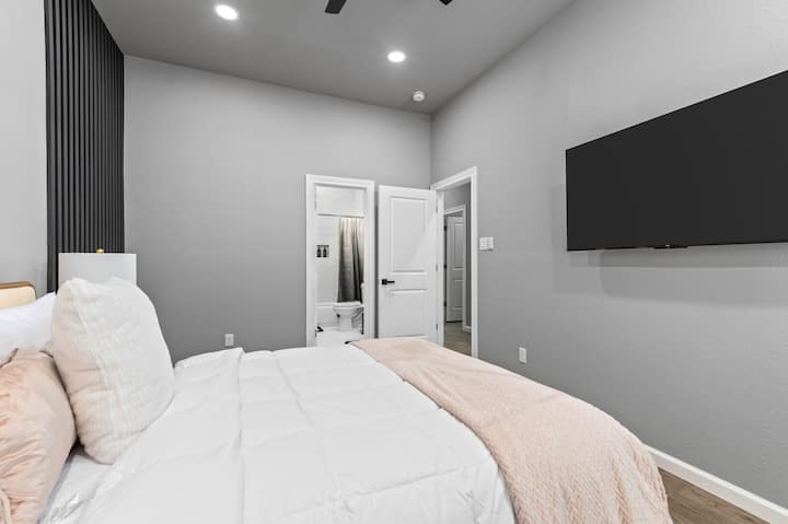 第一间主卧室配备套房浴室，让您舒适地包裹在茧中，配备壁挂电视，配备标准双人床，邀请您沉浸在奢华的怀抱中，在漫长的一天后提供宁静的天堂。