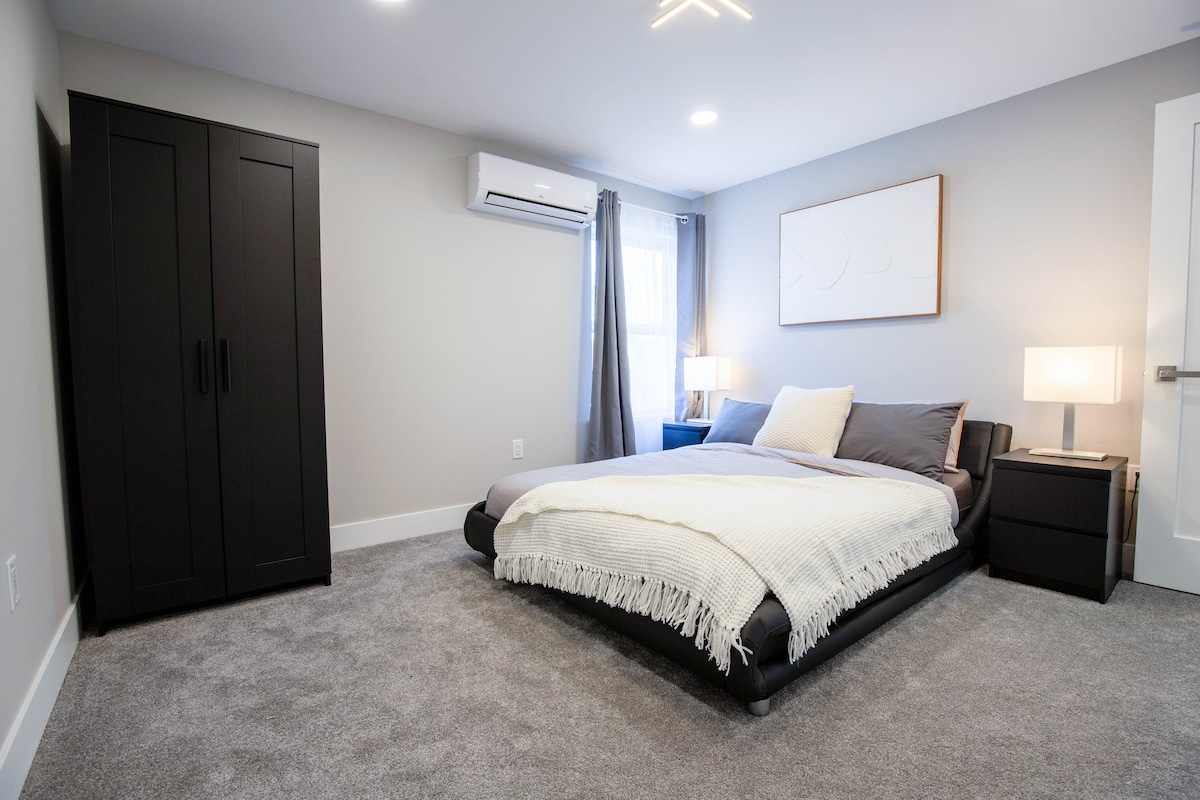 Queensize bed met 4 kussens en katoenen beddengoed.