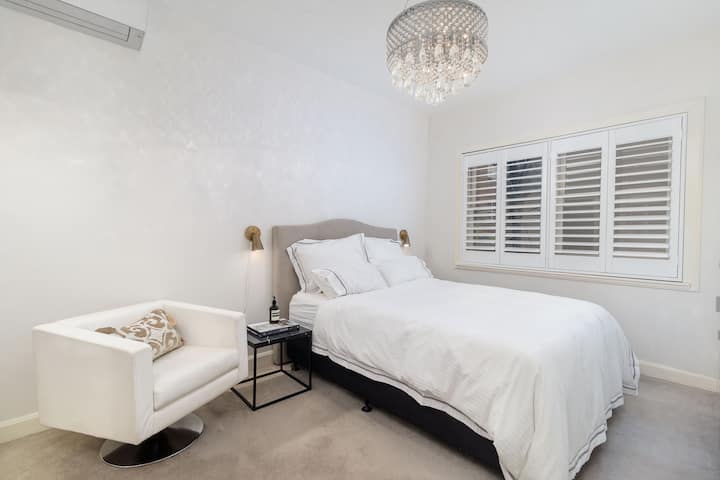 חדר שינה ראשי עם מיטת קווין סייז, מזגן, שידות לילה ומנורות קריאה