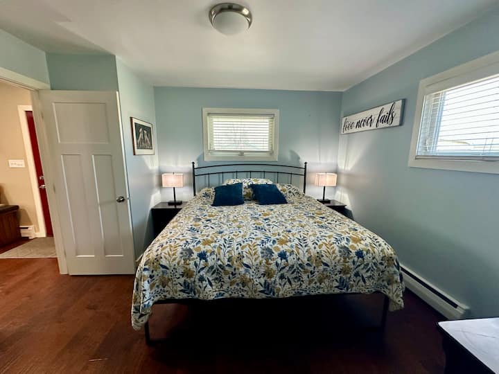 Voel je als een koning in dit gloednieuwe kingsize bed! Kamer met bijzettafels, aanraaklampen, een dressoir en een kleine stoel.