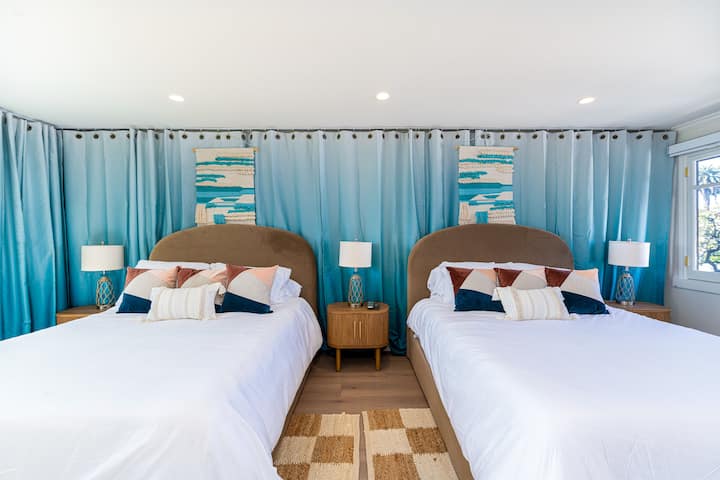 Две спални с две легла с много място за отдих – гледка към океана, специална работна станция и тъмни завеси за спокоен сън.