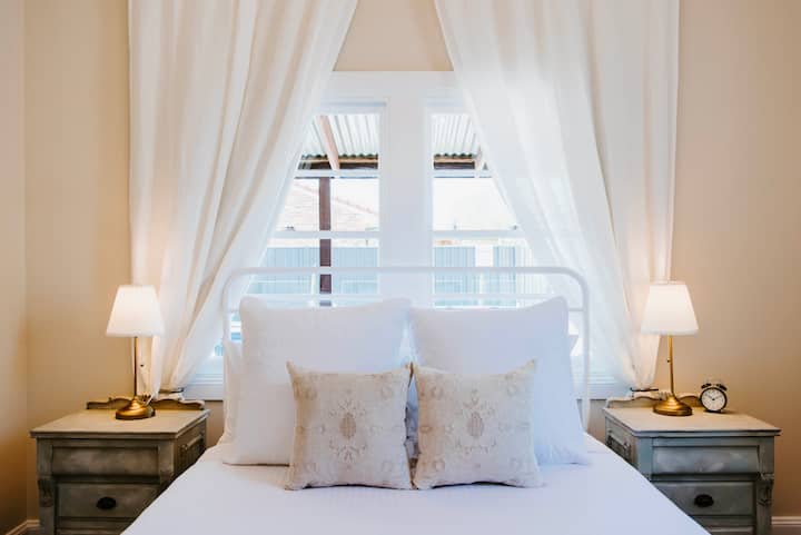 Our elegant Bianca Room is framed by flowing linen drapery and offers serene views of the pool. Every window throughout the house is dressed with airy linen curtains, complemented by a blackout layer to ensure both privacy and restful sleep.