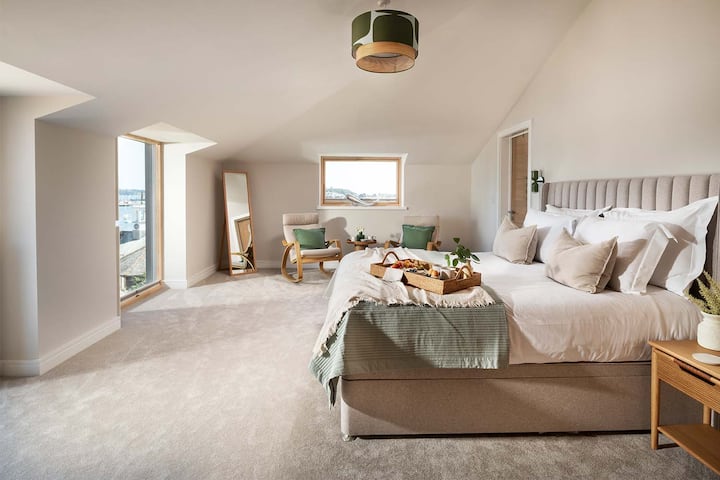 Super-king de 6 pieds avec couette et oreillers en soie, tables de chevet, éclairage de chevet, miroir debout pleine longueur, coiffeuse, tabouret, rangement pour vêtements, chaises et vue imprenable sur le port du sol au plafond. Télévision connectée cachée de 48pouces devant le lit.