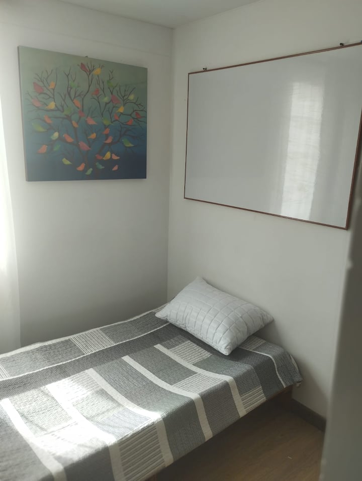 Kamer met eenvoudig bed en ingebouwde kast.