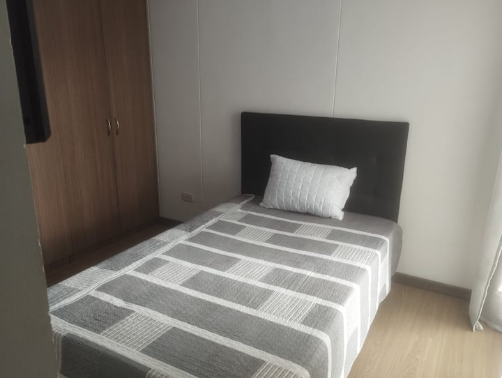 Hoofdslaapkamer met tweepersoonsbed, ingebouwde kledingkast, badkamer met warm water en tv.