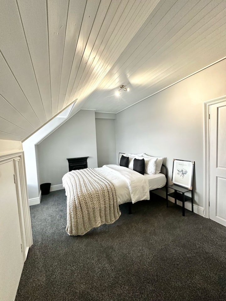 Пространа соба со удобен брачен кревет, ноќни масички и доволно простор за складирање облека. Големото огледало додава малку елеганција, создавајќи релаксирачки и функционален простор за вашиот престој. Совршено за мирно и организирано искуство.