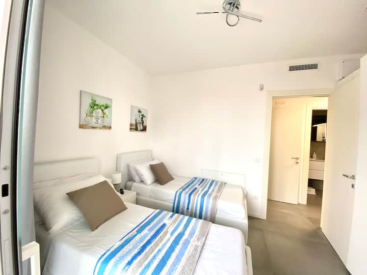 Des matelas confortables vous enveloppent dans une étreinte de détente, tandis que les fenêtres s'ouvrent sur la terrasse pour un réveil de rêve... et une grande armoire pour vous habiller avec style ! Parfait pour rêver... et se réveiller heureux !