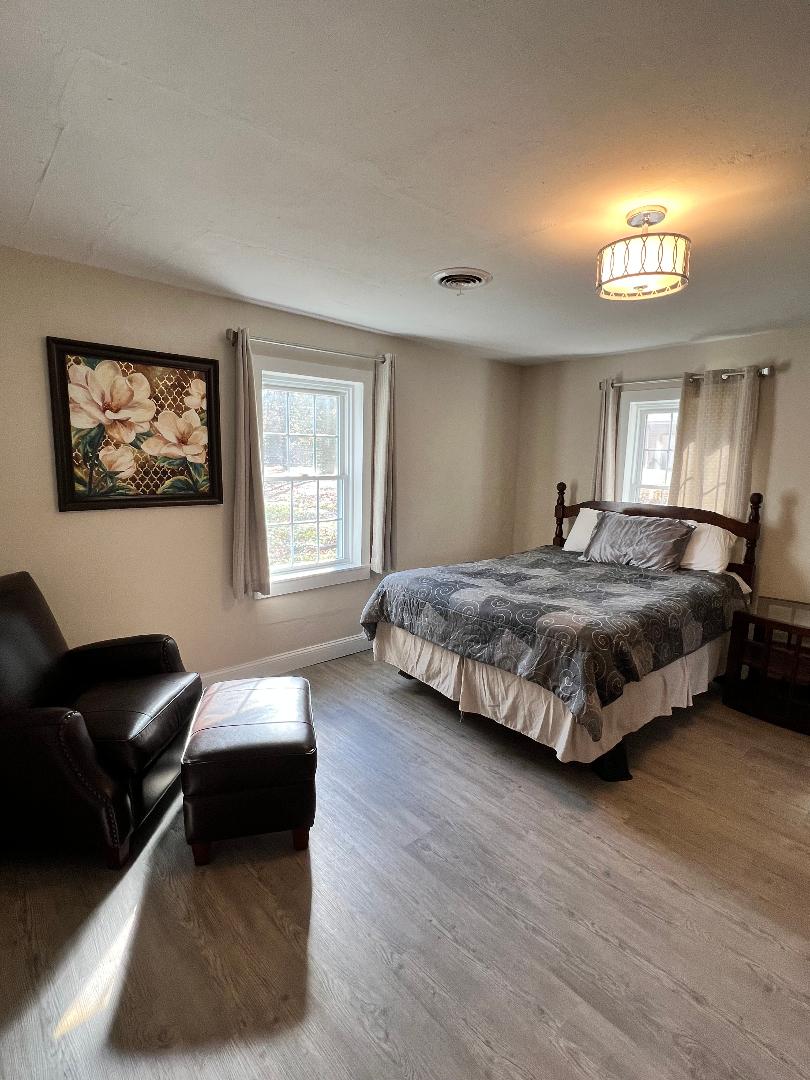 主卧配有舒适的椅子、脚凳、梳妆台和衣橱