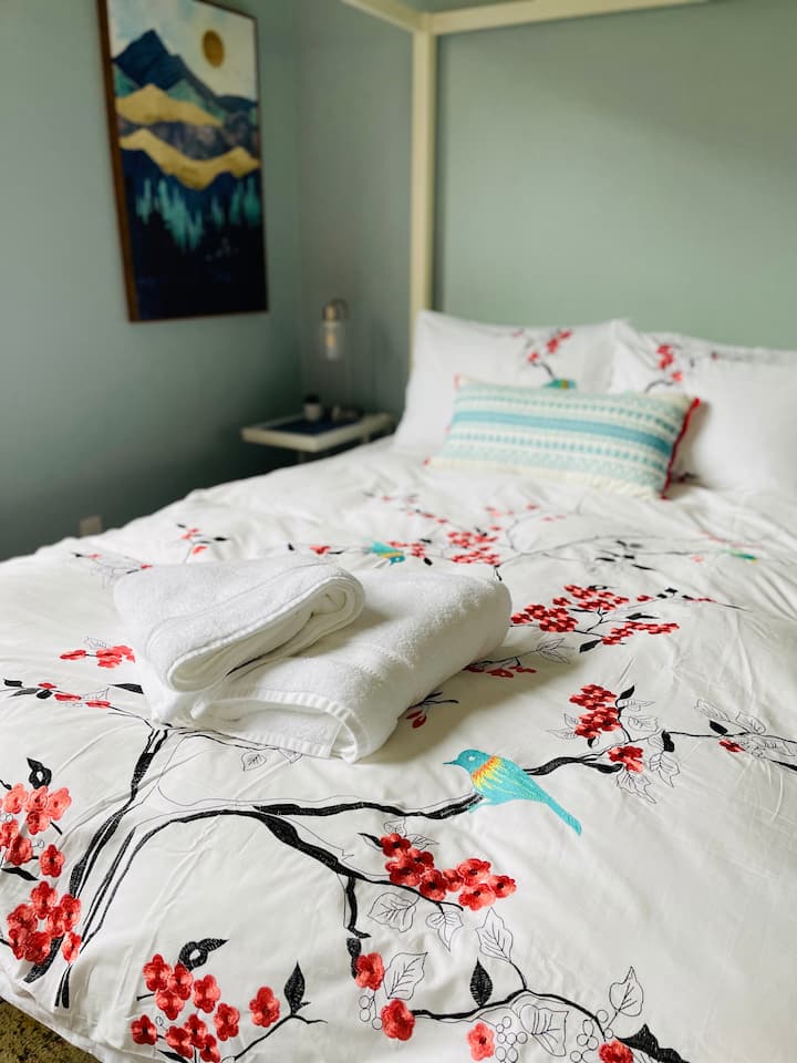 Შედით დედოფლის ზომის კალაპოტის საწოლში ლუქს-კლასის ზეწრებითა და პლუშის საბნით.  Ტუმბოებს აქვს ლამპები, რომლებიც ჩამონტაჟებულია თქვენი დამუხტვის საჭიროებებისთვის. 