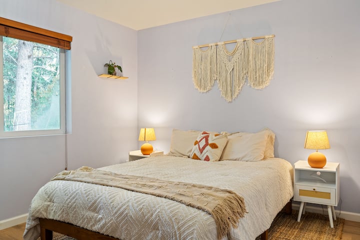 Nježne boje zemljane palete i ugodne teksture čine ovu spavaću sobu u boho stilu mirnim mjestom za odmor. Uživajte u 55-inčnom pametnom televizoru i punite svoje uređaje izravno iz noćnih ormarića, a kad se probudite, uživat ćete u pogledu na šumu i toplom jutarnjem svjetlu.