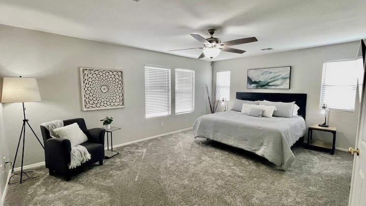 Dormitorio principal (arriba) con vestidor. TV en la pared. Zona de estar. El baño adjunto tiene una bañera de jardín, una ducha a ras de suelo y lavabos dobles. 