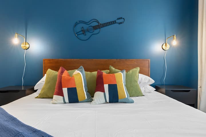 Bedroom: Vibrant blue walls and eclectic pillows create the perfect Nashville retreat!