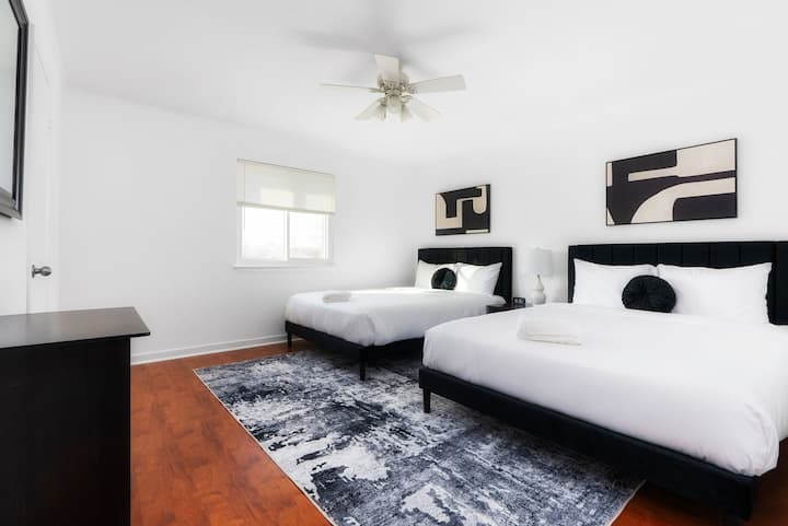 Este quarto no andar de cima possui duas camas queen, oferecendo muito espaço para uma noite de sono tranquila. As persianas blackout garantem um ambiente escuro e pacífico, enquanto a decoração moderna e a roupa de cama macia criam um ambiente acolhedor e convidativo.