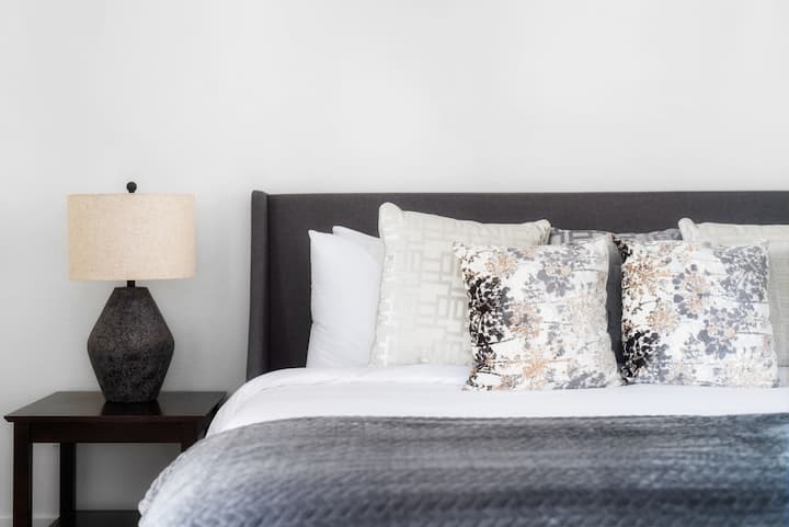 Mergulhe na luxuosa cama king size, completa com lençóis luxuosos e travesseiros confortáveis. Projetado cuidadosamente, este espaço inclui um despertador, um armário de tamanho completo e muitas gavetas para manter seus pertences organizados durante sua estadia.