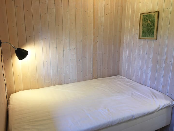 El segundo dormitorio tiene una cama ancha de 120 cm x 200 cm. Además, un escritorio más pequeño con una silla de oficina. Un espacio de trabajo ideal para el hogar sin interrupciones. 
