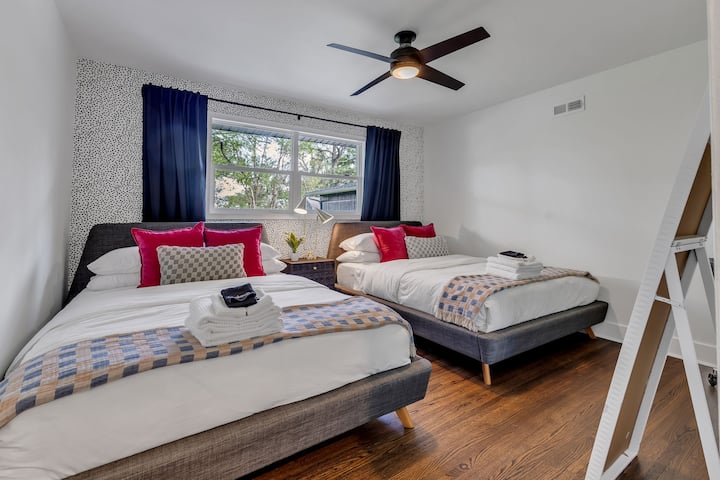 חדר שינה 2 כולל שתי מיטות קווין סייז נוחות, עם נוף לחצר האחורית הפרטית.