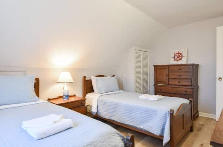 Deux lits jumeaux situés à l'étage avec climatisation et câbles de recharge.