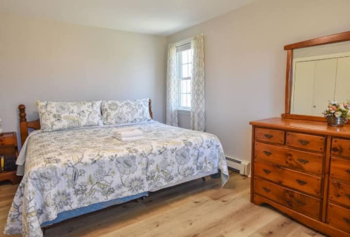 Lit King Size situé au premier étage avec climatisation et câbles de recharge. 