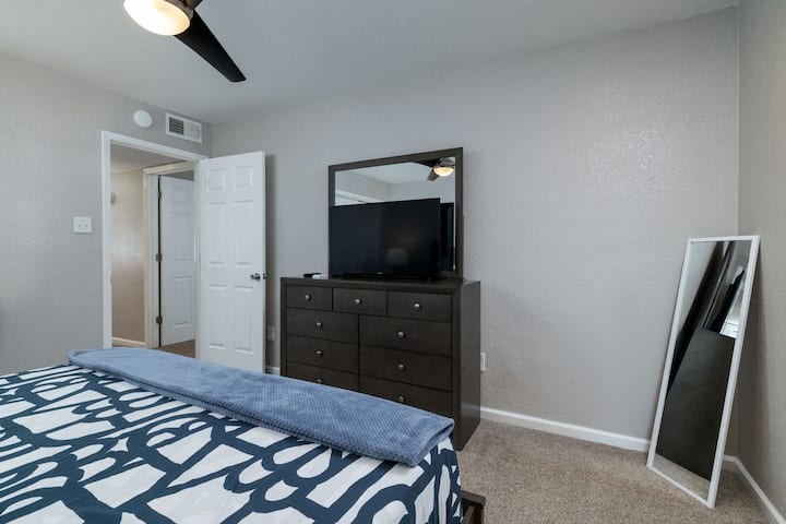 Cómodo dormitorio con TV y ventilador de techo