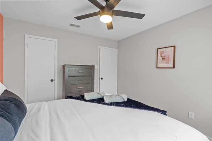 Manželská posteľ s nočnými stolíkmi a komodou.