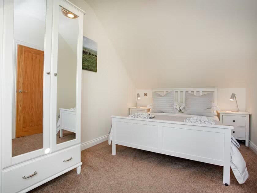 Spavaća soba s bračnim krevetom, ormarom i komodom. USB utičnice za punjenje.