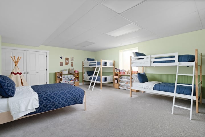 The bright and spacious family-friendly third bedroom features two sets of bunk beds and a queen bed. With playful decor and plenty of toys and books, it's perfect for kids or groups.